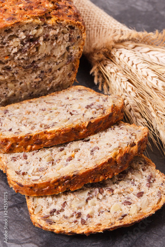 Slices of wholegrain bread for breakfast and ears of rye or wheat grain