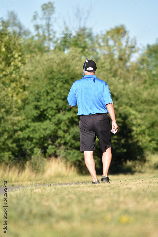 Adult Male Athlete Outdoors With Golf Club Walking