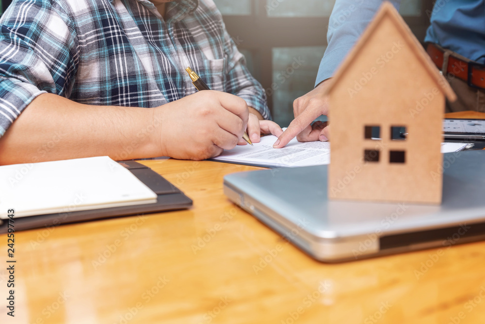 Real estate agent showing his client where he has to sign a contract on sealing deal. Real estate agent showing his client where he has to sign a contract on sealing deal.