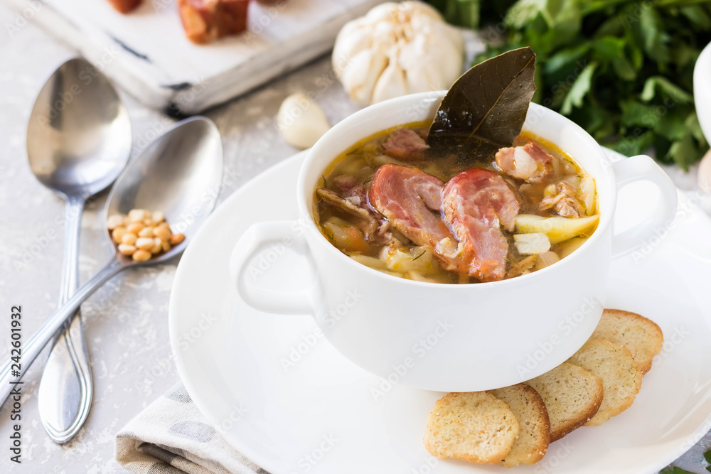 Thick pea soup with smoked meats in a white plate Thick pea soup with smoked meats in a white plate