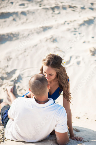 Loving couple on the beach shore in the sand hugging. The concept of love and a date at sea