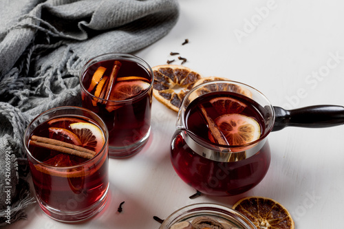 Mulled wine in glasses with orange and spices near gray scarfю