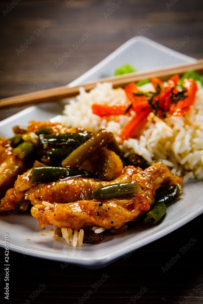 Grilled meat, white rice and vegetables on wooden table Grilled meat, white rice and vegetables on wooden table