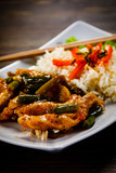 Grilled meat, white rice and vegetables on wooden table