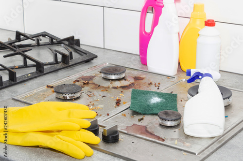 Cleaning a gas stove with kitchen utensils, household concepts, or hygiene and cleaning.