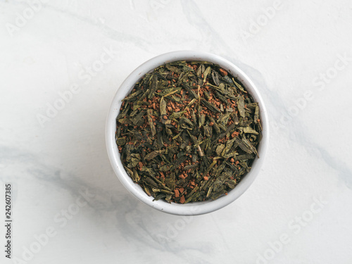 Trendy drink idea: Tea-Coffee Blend Combines Two Popular Drinks. Small bowl of dry mix of green tea and ground roasted coffee beans. Top view or flat lay. Copy space