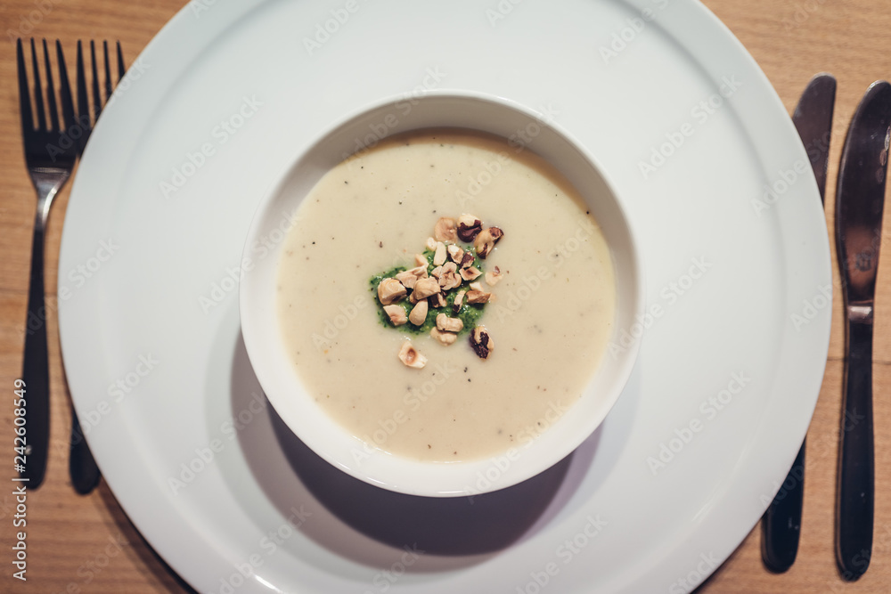 Sunchoke soup with roasted peanuts in white bowl Sunchoke soup with roasted peanuts in white bowl