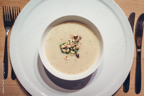 Sunchoke soup with roasted peanuts in white bowl