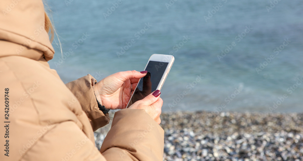 Beautiful Woman Using Smart Phone On A Beach