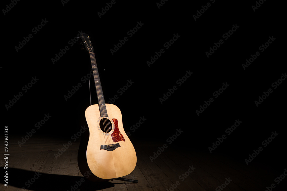 Fototapeta Acoustic guitar on black background with copy space
