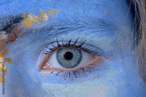 detail of eye in blue painted face