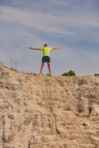 Man celebrating success after good training / exercise on the top of a hill. © astrosystem