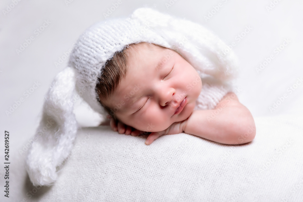 Portrait eines friedlich schlafenden, neugeborenen Babys auf einer weißen Decke