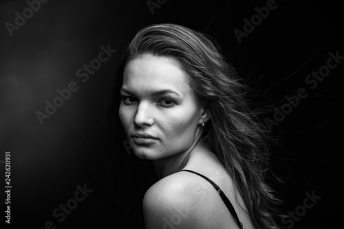 Dramatic black and white portrait of a beautiful girl on a dark background © Restyler