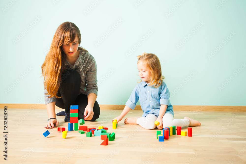 Naklejka premium Young teacher sitting on a floor communicating with her pupil