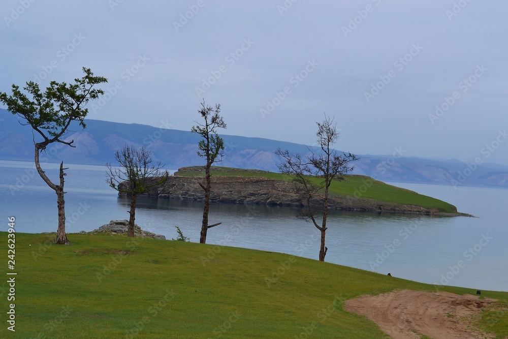 Lake, pines, mountains, island on a cloudy summer day. Lake, pines, mountains, island on a cloudy summer day.
