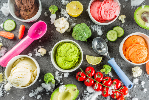 Trendy vegan food  summer healthy dessert concept  colorful diet vegetable ice cream with avocado  cucumber  tomato  beet  carrot  broccoli  cauliflower. Frozen veggie smoothie  black background