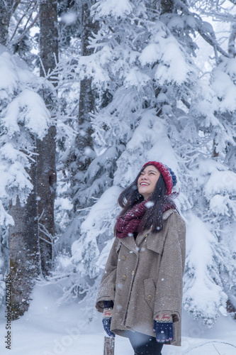 Portrait of woman with red wool hat feeling very happy and cold under snowy weather at Shin-hotaka, Japan Alps.