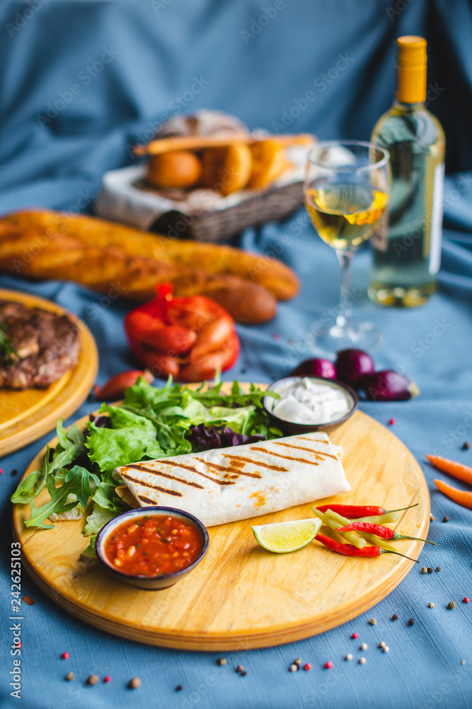 pita kebab on a table with wine and snacks