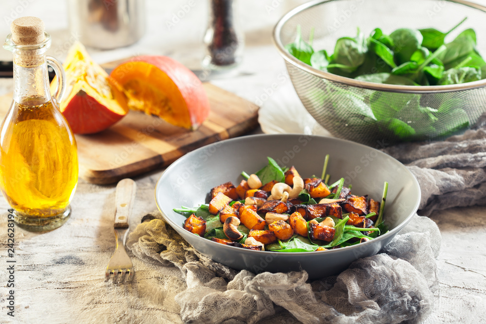 Roasted pumpkin salad with spinach and nuts