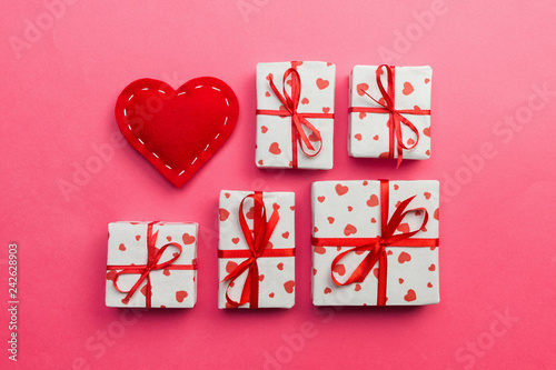 Gift box with red hearts on coral background. top view with copy space