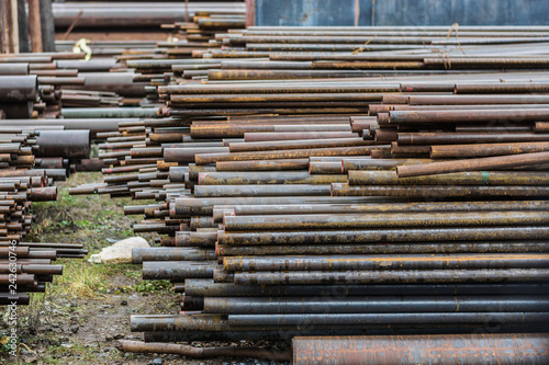 Metal rolling. A round tube are stacked in storage for sale and loading in stock in the open air. Close-up.