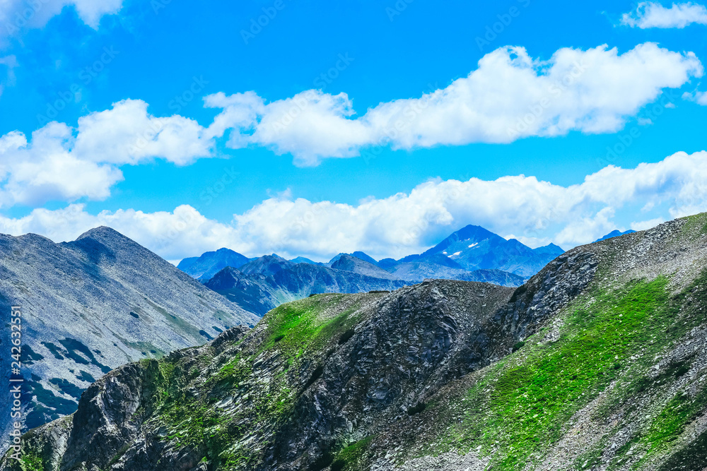 Beautiful alpine high mountains peaks, blue sky background. Amazing Mountain hiking paradise landscape, summertime.