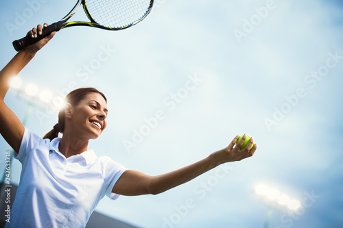 Woman tennis player smiling while holding the racket during tennis match © NDABCREATIVITY