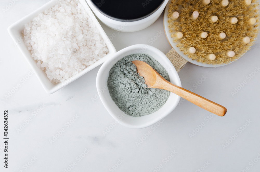 Top view of bottle with cream for face,clay and spoon,bath salt on marble table Top view of bottle with cream for face,clay and spoon,bath salt on marble table