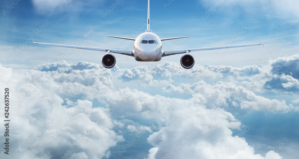Obraz premium Commercial airplane jetliner flying above dramatic clouds.