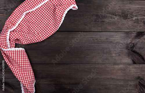 red textile towel in a white cell on a brown wooden background