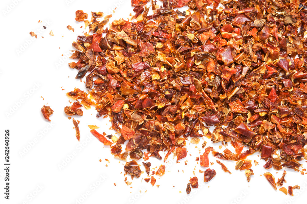 Pile crushed dried red pepper flakes, on white background