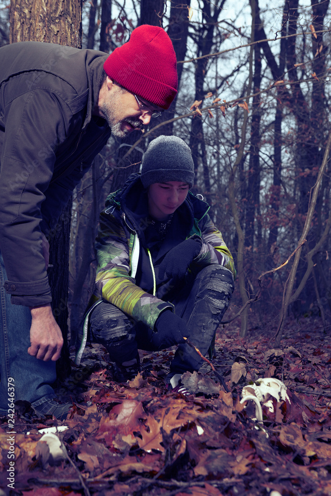 Couple of father and son found human skeleton when walking in winter forest Couple of father and son found human skeleton when walking in winter forest