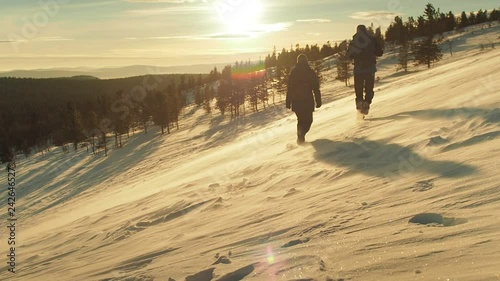 Man And Woman Couple Hiking Climbing Mountain Slope Winter Vacation. People Mountaineering Winter Snow Landscape. Snow Expedition Explore Peak Concept. photo