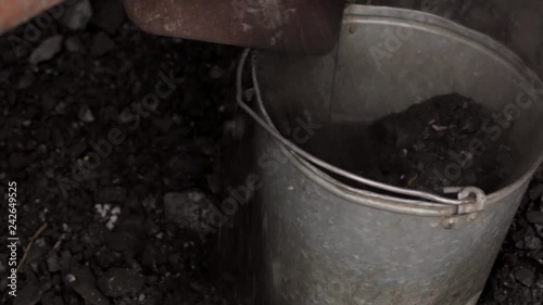 heating of a country house with coal, a man loads coal in a bucket photo