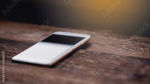White phone with screen on the wooden background