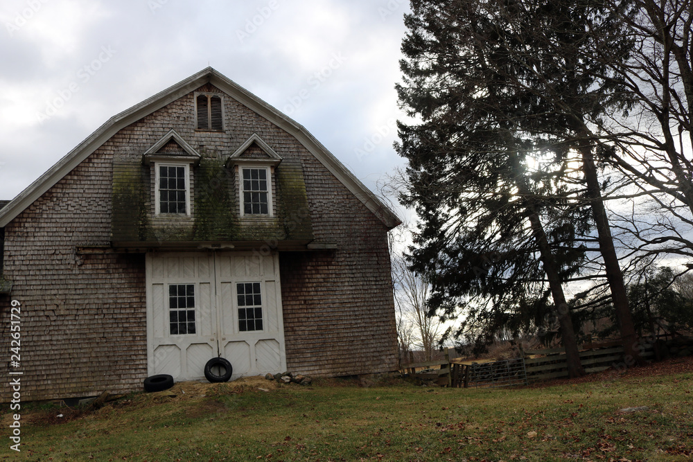 Old weathered rustic wooden barn on historic New England farm Old weathered rustic wooden barn on historic New England farm