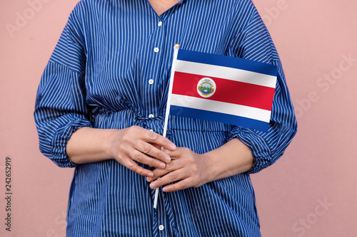 Costa Rica flag. Close up of a woman's hands holding Costa Rican flag.