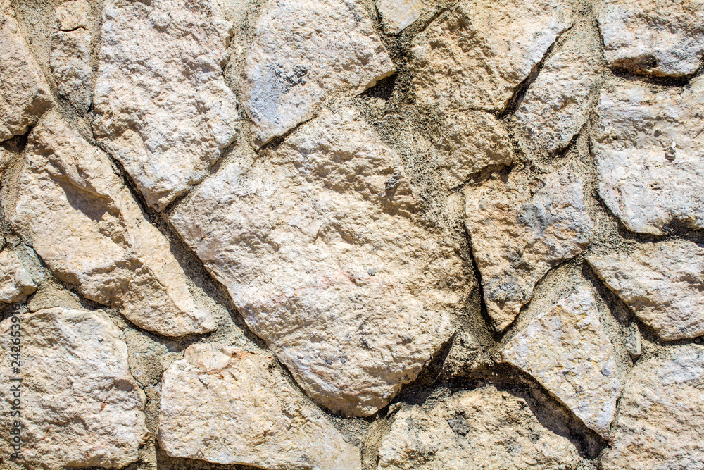 White Stoned Wall in Uneven Cut for Background. Closeup View of Chalky Dry Rock Formation in Abstract. Crazy Pattern of Rock Paved Structure Art of Masonry White Stoned Wall in Uneven Cut for Background. Closeup View of Chalky Dry Rock Formation in Abstract. Crazy Pattern of Rock Paved Structure Art of Masonry