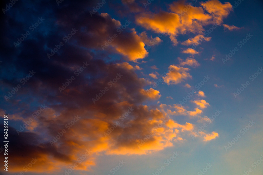 Colors of Afterglow Illuminating the Blue Sky. Gray and Golden Clouds Forming an Abstract Cloudscape Artwork. Colourful and Dramatic Thick Fog Scattering