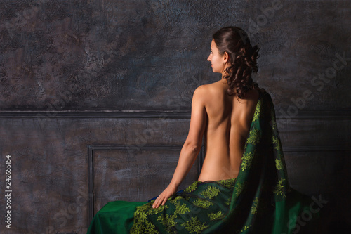 Beautiful girl with curls with a naked back. Back view © Evgeniya_St