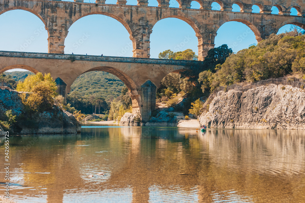 Beautiful view of the ancient Roman bridge Pont du Gard from the middle of the river Gardon