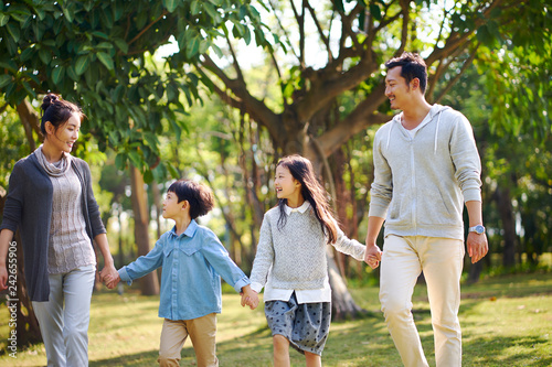 Photography asian family with two children walking relaxing having fun in park