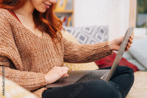 Young redhead woman working on a laptop