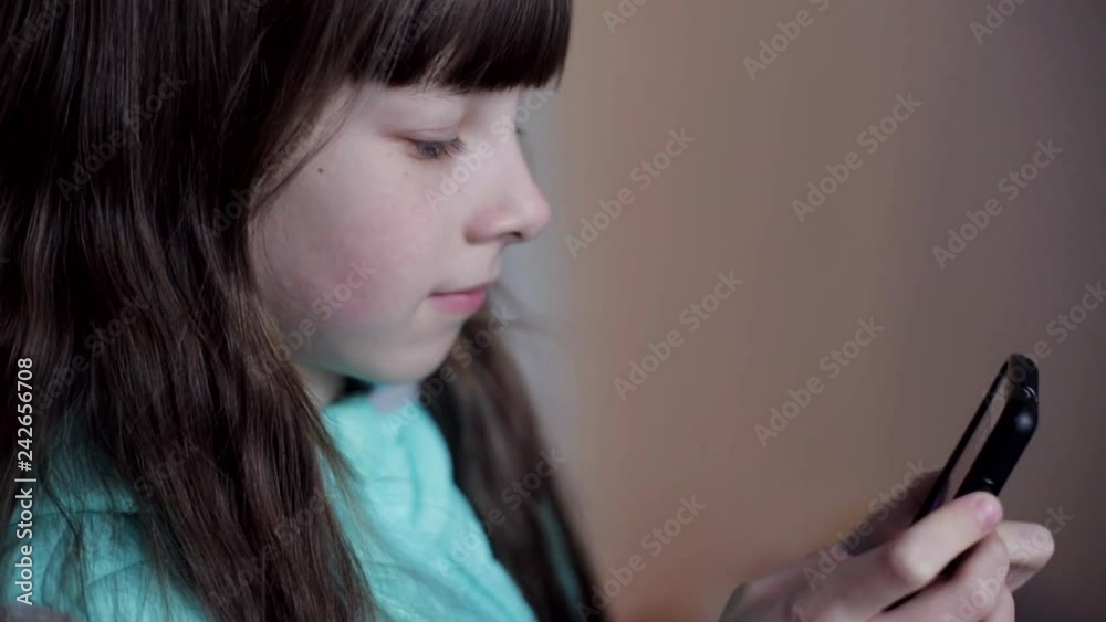 close-up portrait of a Caucasian teenage girl playing on a smartphone online game close-up portrait of a Caucasian teenage girl playing on a smartphone online game