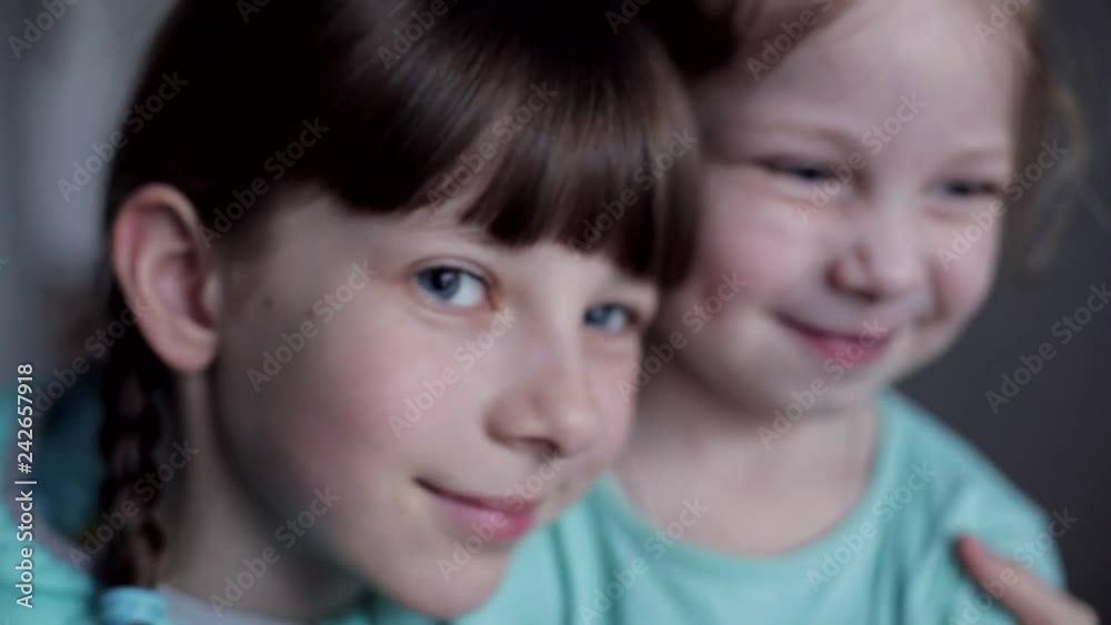 close-up portrait of two Caucasian sisters hugging each other close-up portrait of two Caucasian sisters hugging each other