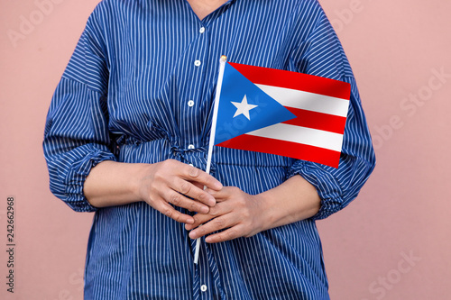 Puerto Rico flag. Close up of a woman's hands holding Puerto Rican flag.	 photo