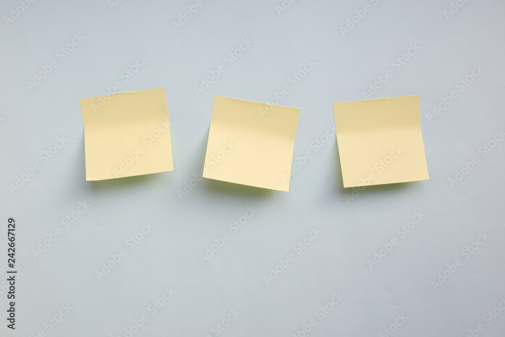 Three yellow paper stickers note with copy space on blue background Three yellow paper stickers note with copy space on blue background
