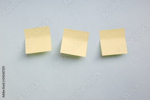Three yellow paper stickers note with copy space on blue background