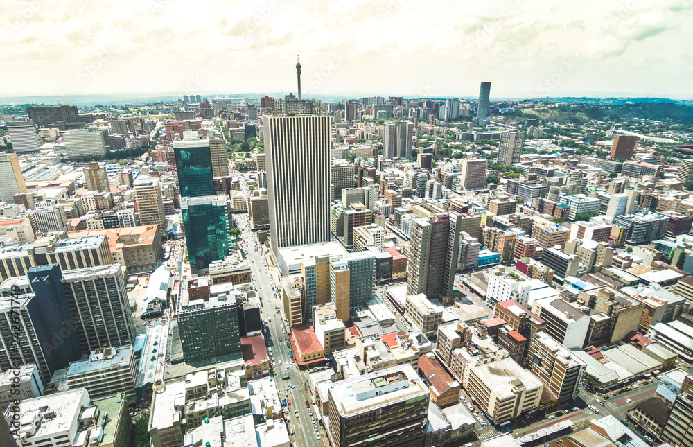 Naklejka premium Widok z lotu ptaka na panoramę drapaczy chmur w biznesowej dzielnicy Johannesburga - Koncepcja architektury z nowoczesnym budynkiem w wielkim mieście RPA - Krajobraz na zdesaturowany dramatyczny filtr